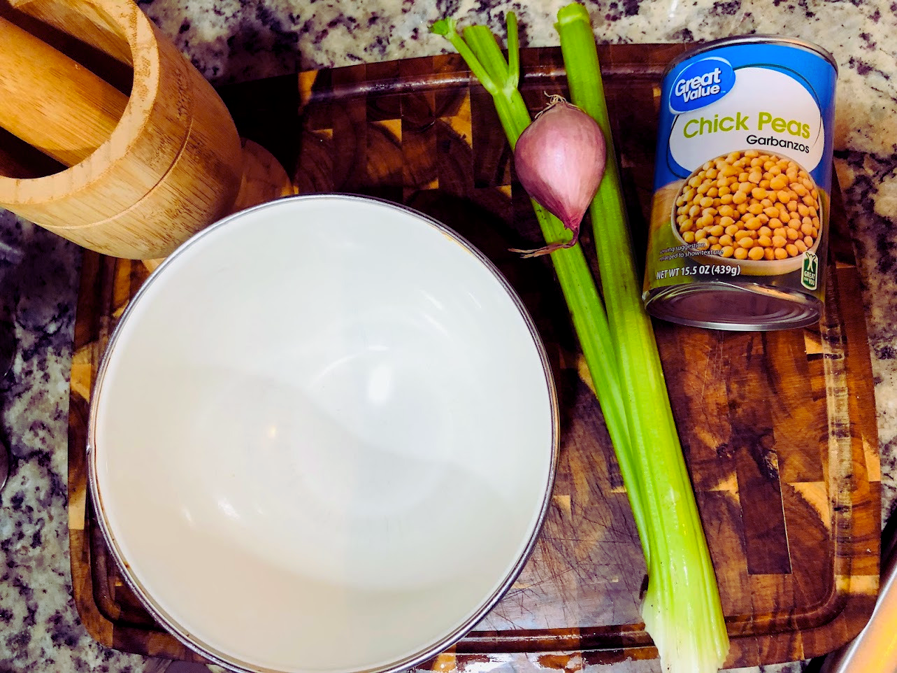 Can of chickpeas, celery, shallots and bowl on a cutting board