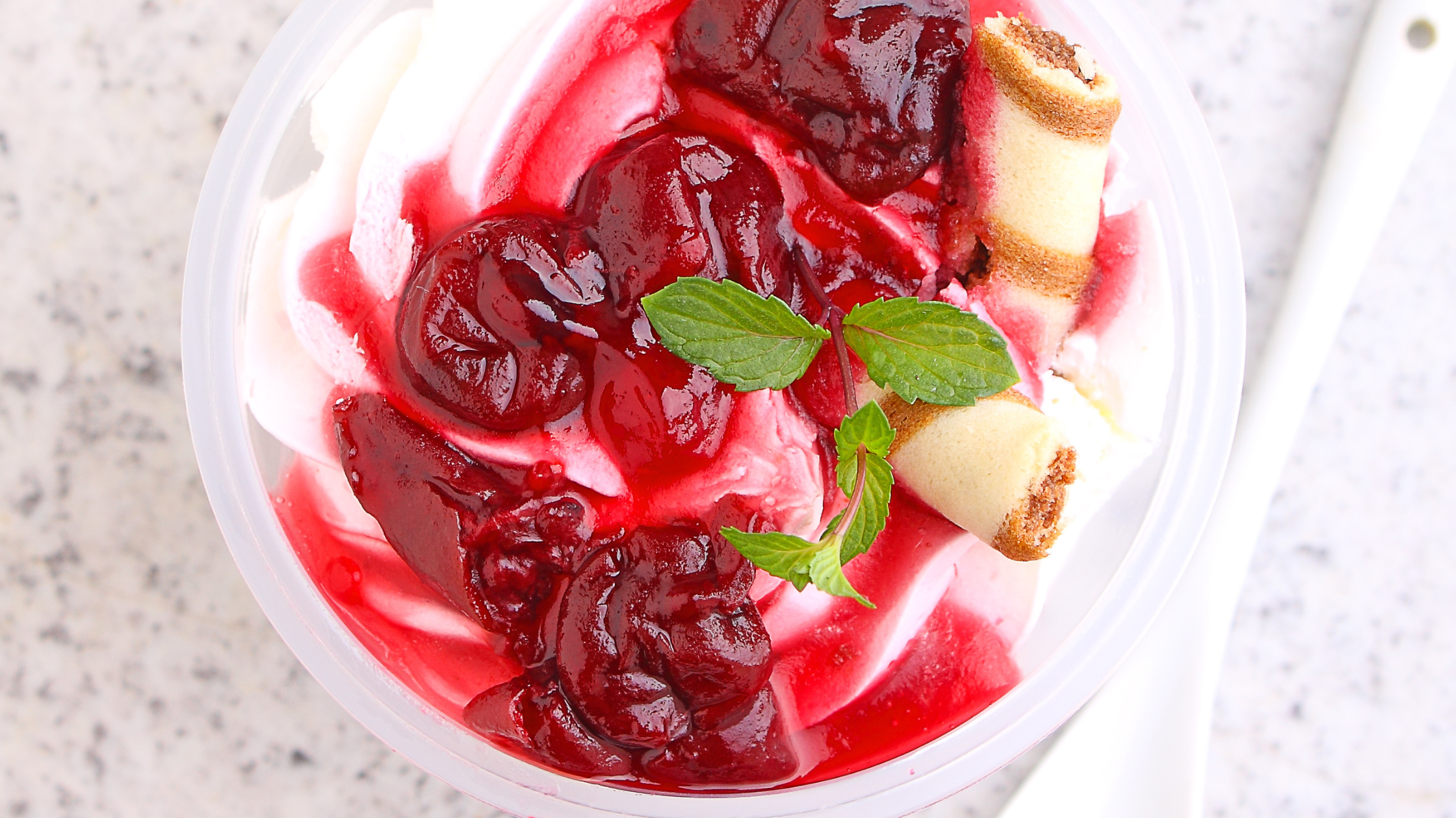 Cheesecake parfait with cherries on top and sprinkle of mint 