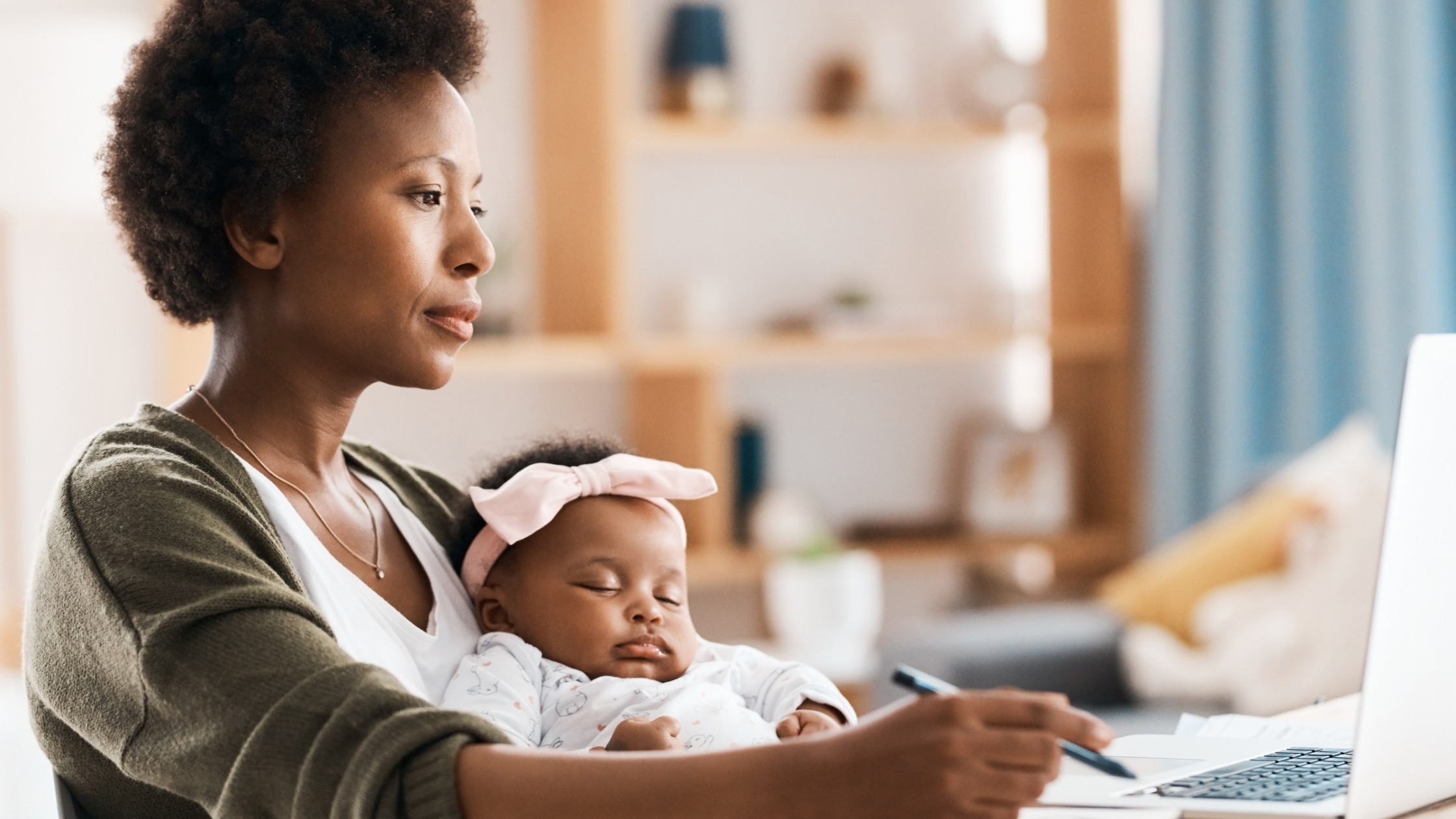 Mom working from home holding baby.