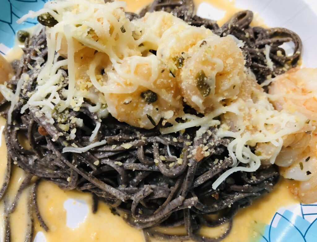 Cooked black soybean pasta with shrimp on top