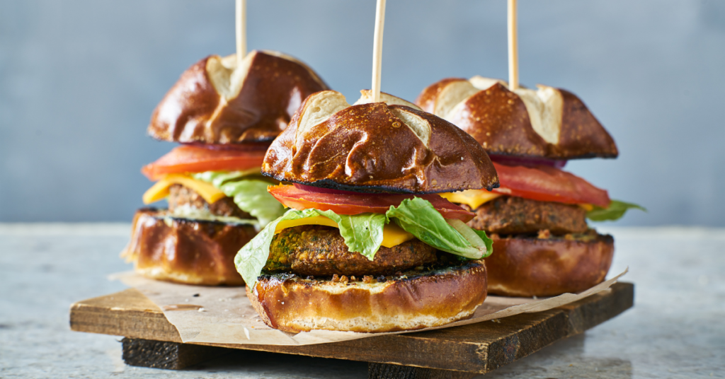 a group of burgers on a wooden board