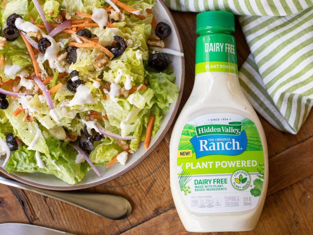 a salad on a plate next to a bottle of dairy free ranch dressing