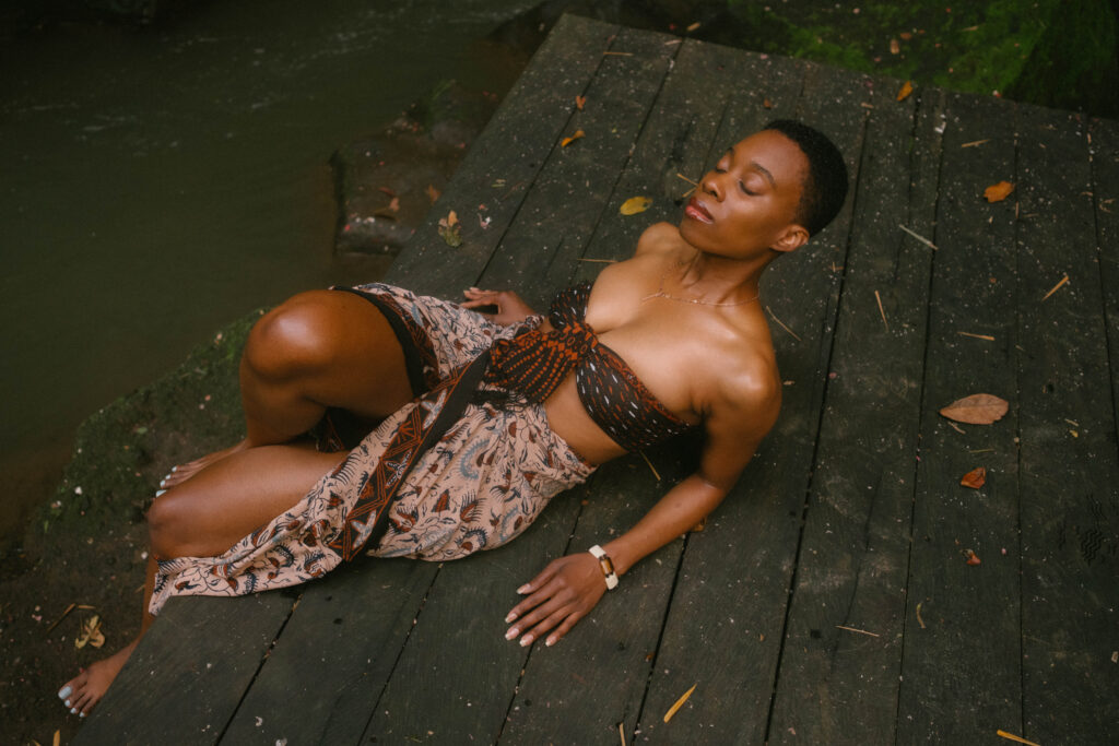 Black woman with natural hair in a beach wrap resting in a jungle_How to enjoy life